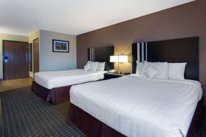 格伦代尔高地格伦代尔高地艾迪生区华美达酒店的配有白色床单的酒店客房内的两张床