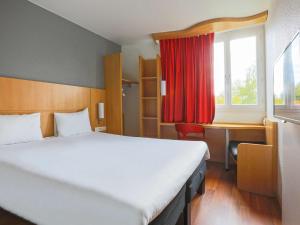 香槟沙隆宜恩沙隆香槟酒店的一间卧室配有一张床、一张书桌和一个窗户。