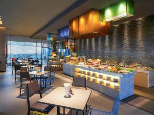 曼谷宜必思尚品曼谷素坤逸康福酒店的一间带桌椅的餐厅以及一间自助餐