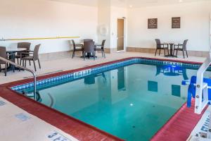 圣安东尼奥Comfort Inn near Frost Bank Center的酒店客房的游泳池配有桌椅