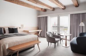 哥本哈根哥本哈根埃德莫瑞酒店的一间卧室配有一张床铺、椅子和一张桌子