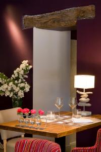 多尔多尼河畔博利厄Logis hotel les flots bleus的一张桌子,上面放着酒杯和鲜花