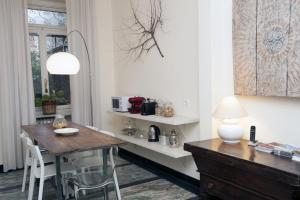 都灵B&B Torino Crocetta的一间带木桌和椅子的用餐室