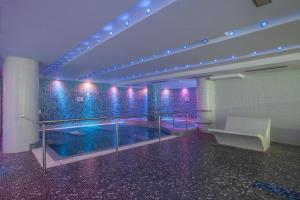 索尔德乌Wuau! Hotel Galanthus & Spa的紫色和蓝色灯光的建筑中的游泳池