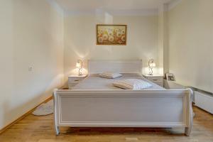 维尔纽斯Vidos apartamentai 2的一张白色的床,房间有两个床头柜