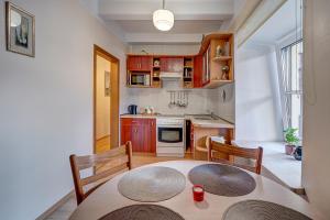 维尔纽斯Vidos apartamentai 2的小厨房配有桌子、两把椅子、一张桌子和一张桌子。