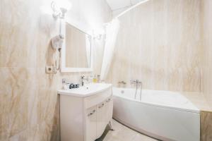 基辅Black Sea Hotel Kyiv的白色的浴室设有浴缸、水槽和浴缸。