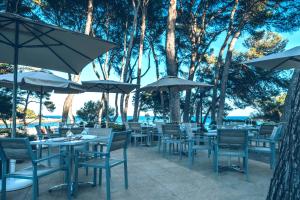 丰德萨卡拉伊波罗之星皮诺斯公园酒店的室外餐厅设有桌椅和遮阳伞。