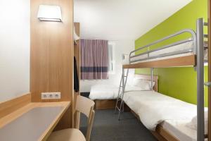 尤塞克B&B HOTEL Brive-la-Gaillarde的小房间设有两张双层床和盥洗盆