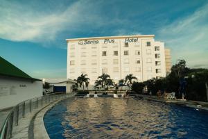 圣玛尔塔Sanha Plus Hotel的大楼前设有游泳池的酒店