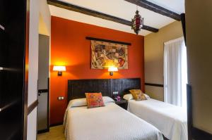梅里达安达卢斯之花酒店的橙色墙壁客房的两张床