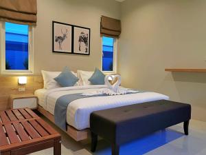 甲米镇The Apex private pool villa Krabi的一间卧室配有一张大床、长凳和窗户