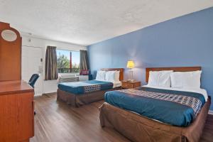 朴次茅斯Economy Lodge Portsmouth的酒店客房设有两张床和窗户。