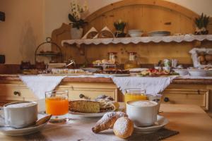 摩德纳迪-坎皮格里奥加尼拉索尔达内拉酒店的桌子,上面有杯子和盘子,还有橙汁