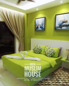 新山INFA@新山赛罗亚公寓的一间绿色卧室,卧室内配有一张床铺