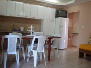 乌巴图巴Budget Apartamento Na Praia Ubatuba的厨房配有桌椅和冰箱。