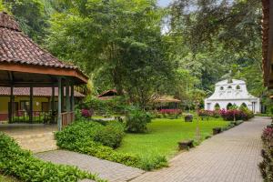 雅科Villa Lapas Jungle Village的一个带凉亭和白色建筑的花园