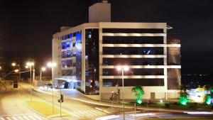 弗洛里亚诺波利斯Iate Hotel Centro Florianópolis的一条白色的大建筑,晚上有街道