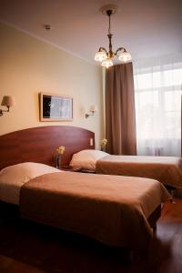 特维尔奥克特亚布斯卡亚酒店的酒店客房设有两张床和吊灯。