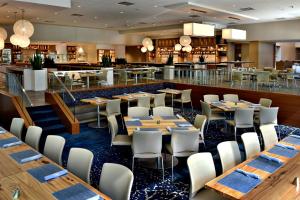 达拉姆JB公爵酒店的一间带桌椅的餐厅和一间酒吧