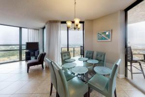 德斯坦Surfside Resort 2 by Vacasa的一间设有玻璃桌和椅子的用餐室
