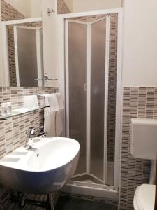 米兰多佛尔酒店的浴室配有白色水槽和淋浴。