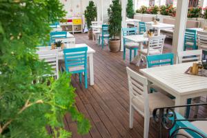 斯维什托夫诺夫酒店的庭院配有白色的桌子和蓝色的椅子。