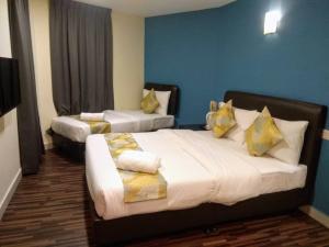 吉隆坡Hotel Sunjoy9 @ Mid Valley的酒店客房 - 带两张带黄色枕头的床