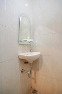 日惹Selaras Inn Syariah的浴室设有水槽和墙上的镜子