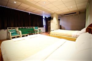 南芭堤雅KKinn South Pattaya的一间酒店客房,配有两张床和椅子