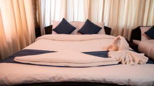 加德满都Hotel Green Horizon的两张带毛巾的床和一只狗躺在床上