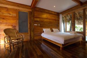 帕他仑Baan​ Tonlamphu​ Pakpra的卧室配有床、椅子和窗户。