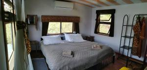 利文斯顿Mama Out of Africa的一间卧室配有一张带白色床单的床和两个窗户。