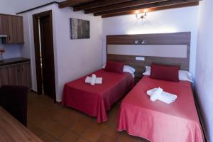 埃尔罗西奥拉方达德尔罗西奥乡村旅馆的红色床单的客房内的两张床