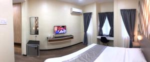 马六甲马六甲度假村的一间酒店客房,配有一张床和一台电视