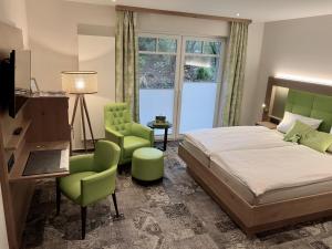 加瑞尔Landhotel Witte-König的一间卧室配有一张床和两张绿色椅子