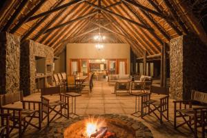 MatlhagameNtamba Safari Lodge的建筑中间带火坑的客厅