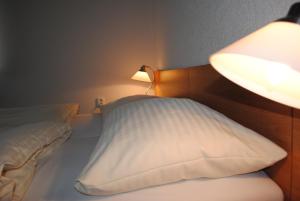 Drnovice阿尔维特酒店的一间卧室配有一张带台灯和枕头的床