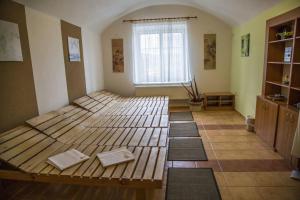 Drnovice阿尔维特酒店的一间铺有地板并配有一张带垫子的木床的客房