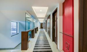 孟买The Legend Hotel- Santacruz Near Mumbai International Airport的走廊上设有蓝色的墙壁和红色的门