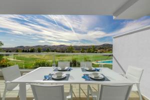 卡拉德米哈斯Apartment front Line La Cala Golf Resort的阳台上配有白色餐桌和椅子
