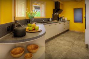 马尼戈Chalet Marinaka - OVO Network的厨房设有黄色的墙壁,柜台上放有一盘水果