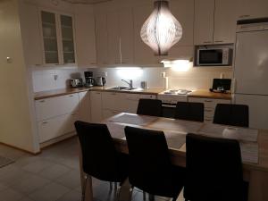 沃卡蒂Vuokatin Lumo的厨房配有木桌和黑色椅子
