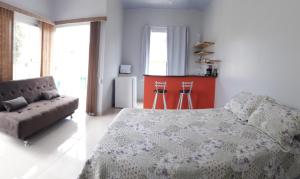 卡瓦坎特Chalés Aconchego的一间卧室配有一张床和一张沙发