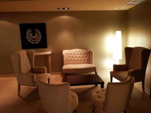 特鲁埃尔波坦尼克斯大酒店的一间设有椅子和桌子及台灯的等候室