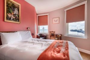 布莱顿霍夫Amsterdam Hotel Brighton Seafront的卧室配有白色的床和2扇窗户。