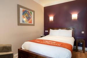 布莱顿霍夫Amsterdam Hotel Brighton Seafront的卧室配有一张床,墙上挂有绘画作品