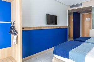 北茹阿泽鲁鲁阿酒店的一间设有床铺和墙上电视的房间