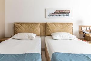 北茹阿泽鲁鲁阿酒店的两张睡床彼此相邻,位于一个房间里