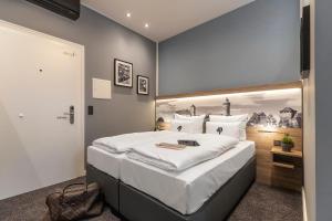 纽伦堡Aparthotel by dasPaul的一间卧室配有一张大床和大床头板